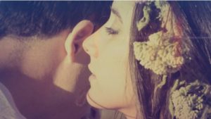 Woman whispering into mans ear