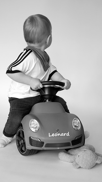 Small child on play car looking backwards