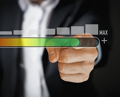 man pointing at 'maximum' on digital gauge superimposed in front of him